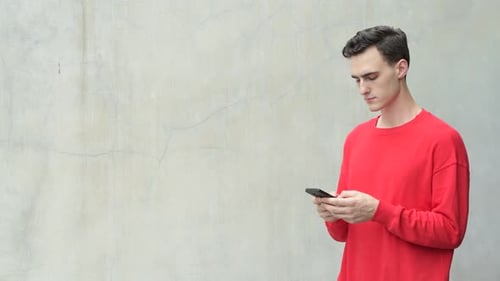 Young Adult Uses Smartphone in Urban Setting