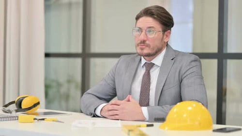 Pensive Middle Aged Engineer Thinking While Sitting in Office