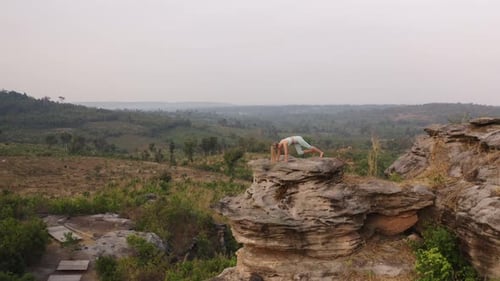 Woman Practicing Yoga Atop Rock Formation