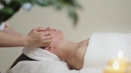 Cute Brunette Woman on Face Massage in Spa Salon