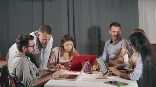 Team Meeting Around Table with Laptops