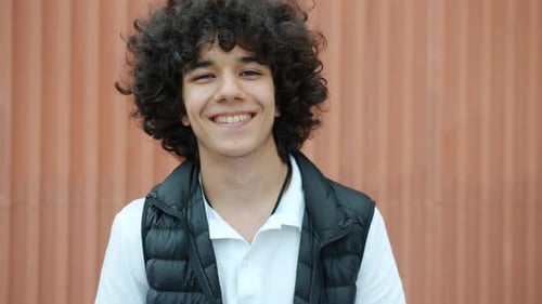 Smiling Teen with Curly Hair Waving