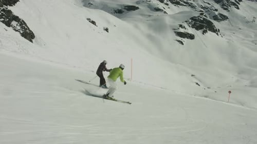 Skiers Descending Snowy Mountain Slope in Winter