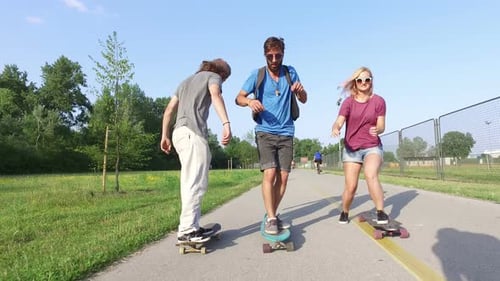 Friends Skateboarding Together on Road in a Park