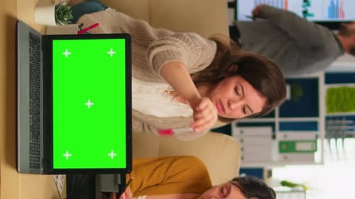 Team Discussing Work with Green Screen Laptop