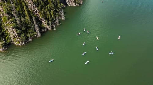 People Ride on SUP Board in the Mountain Lake