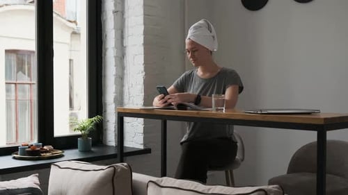 Woman Sits at Home Using Smartphone