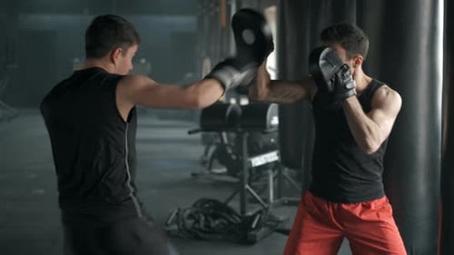 Athletic Man Fighting During the Training with Boxing Trainer at the Gym. Slow Motion