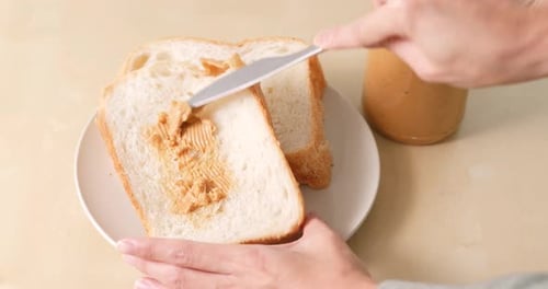 Spreading Peanut Butter on Bread for Sandwich