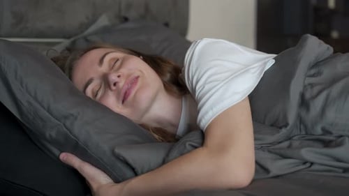 Woman Sleeping Peacefully in Comfortable Bedroom