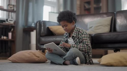 Young Boy Using Tablet Device on Floor at Home