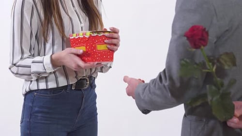 Woman Receives Gift and Rose from Man