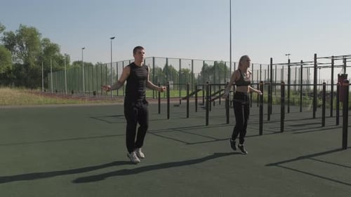 Man and Woman Jumping Rope at Outdoor Gym