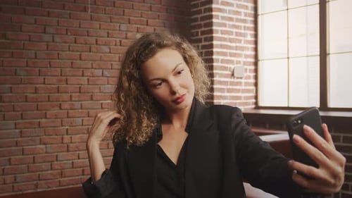 Stylish Woman Taking Selfie Indoors with Smartphone