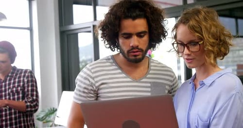 Team Working Together on Laptop in Modern Office