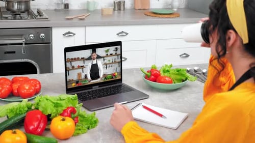 Woman Watches Cooking Video in Bright Kitchen