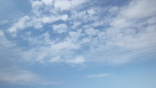Clouds Slowly Drifting Across Light Blue Sky