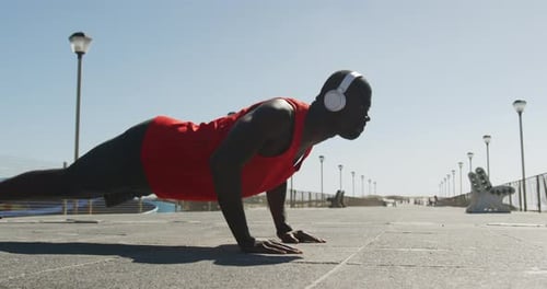 Man Doing Pushups on Sunny Beach Boardwalk