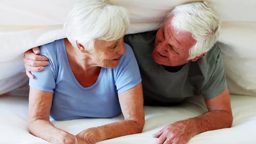 Senior Couple Laughing in Bed Together