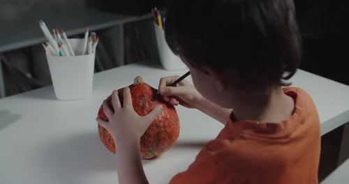 One Boy Decorating and Painting Pumpkin for Halloween