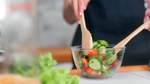 Person Preparing Fresh Vegetable Salad in Kitchen