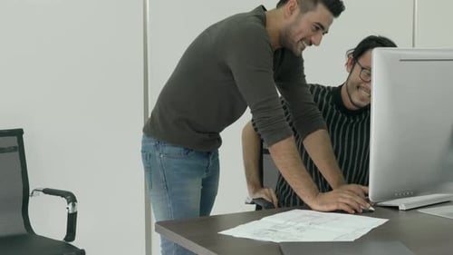 Happy Young Men Work at Computer in Office