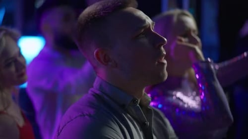 Seitenansicht Nahaufnahme eines vertieften kaukasischen jungen Mannes, der beim Konzert Jubel singt und mit einer Gruppe von