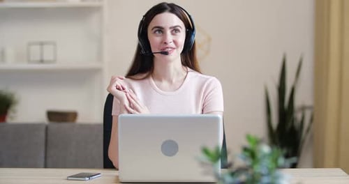 Woman in Headset Working from Home on Laptop