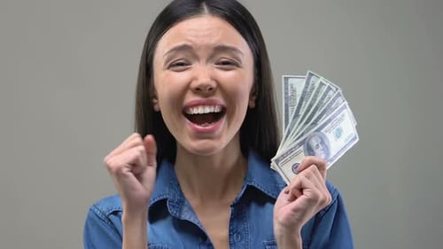 Woman Celebrating with Cash Money in Close Up