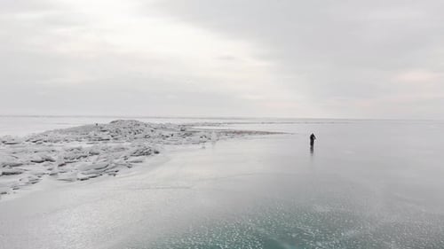 Aerial Shot of Man Riding Bicycle at Frozen Lake