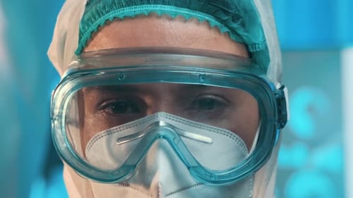 Close Up Caucasian Doctor Virologist Wearing Protective Goggles Looks at Camera