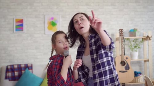 Close Up Mom and Daughter Emotionally Sing Karaoke at Home