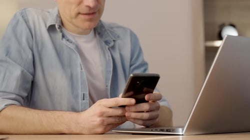 Abgeschnittene Ansicht des kaukasischen Mannes, der sein Handy zum Telefonieren benutzt, während er am Schreibtisch sitzt