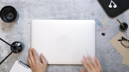 Hands opening laptop, putting smartphone on table and start working.