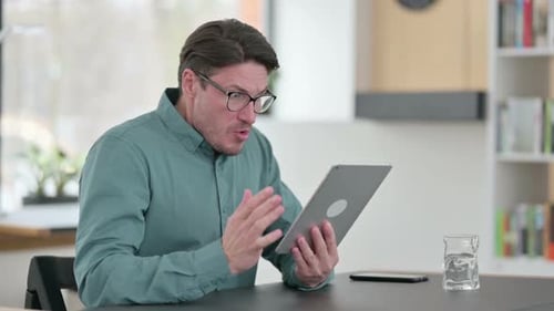 Man Reacting with Disbelief While Using Tablet at Home