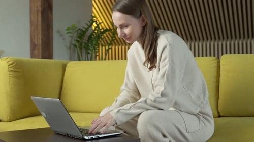Woman Types on Laptop in Bright Home Setting