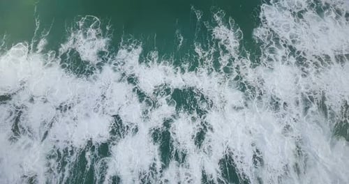 Drohne Vertikale Aufnahme einer riesigen Welle des Wilden Ozeans, die herunterstürzt und eine erstaunliche Meeresschaum-Textur erzeugt