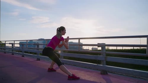 Woman Stretching Outdoors on Pedestrian Bridge in City