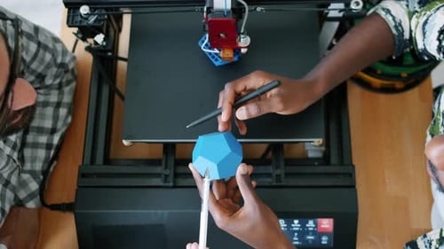 Männliche Designer mit 3D-gedruckter Form diskutieren Design während des Maschinendrucks