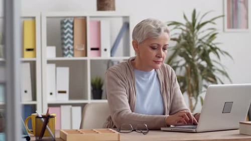 Porträt einer Seniorin, die im Büro arbeitet