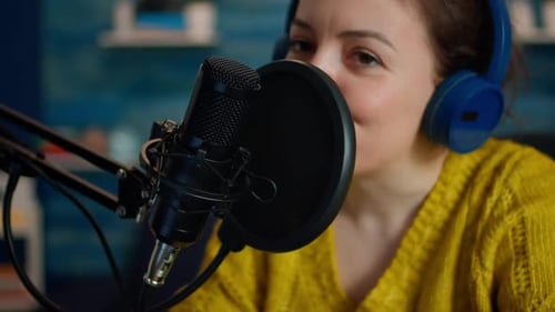 Woman Recording Podcast into Microphone with Headphones