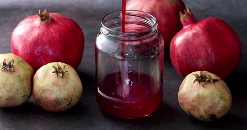 Pomegranate Juice Being Poured into Jar