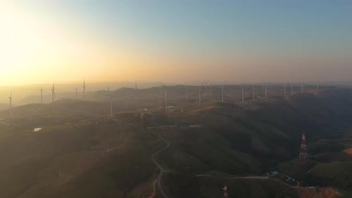 Aerial view of powerful Wind turbine farm for energy production on beautiful cloudy sky at highland.