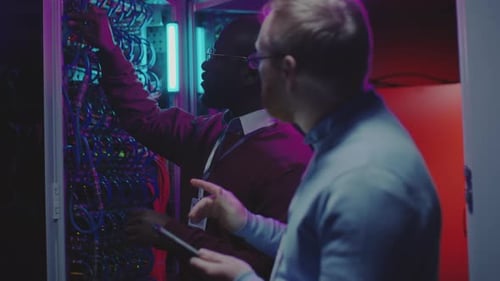 Multiethnic Data Center Technicians Working in Server Room