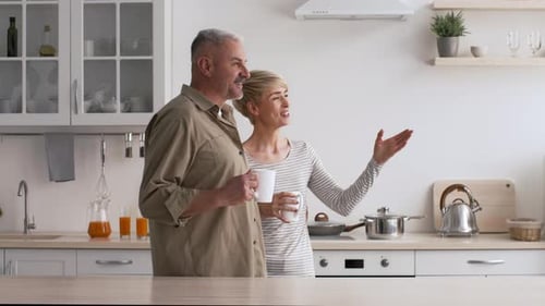 Relaxed Couple Enjoying Coffee Together in Modern Kitchen