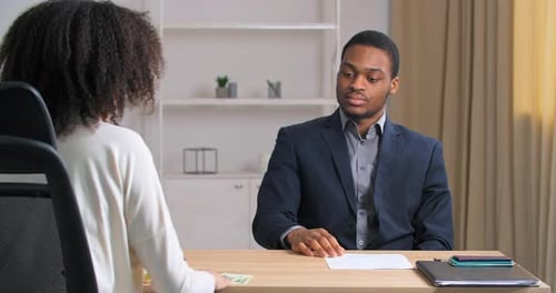 Unrecognizable Businesswoman Grateful Client with Curly Hair in White Shirt Sits at Office Table