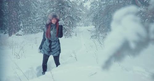 Belle fille marchant le long du chemin entre les congères dans la forêt