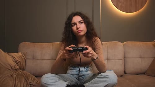Bored Woman Yawns Playing a Video Game at Home at Night