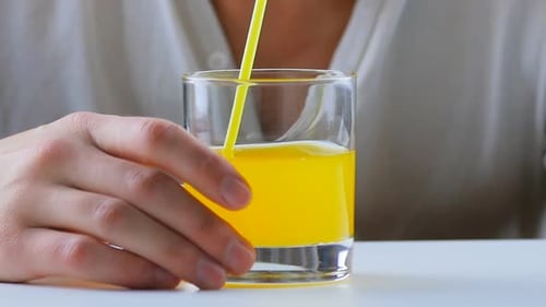 Man Drinking Orange Soda with a Straw