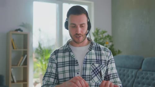 Young Adult in Plaid Shirt Wearing Headset